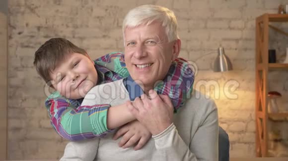 祖父和孙子拥抱年轻的胖男孩和年迈的祖父幸福家庭概念60f视频的预览图