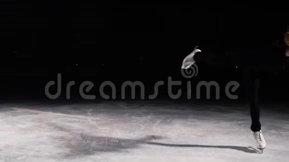 一个女孩在冰面上的特写镜头绕着她的轴旋转同时单腿站在冰面上照相机视频的预览图