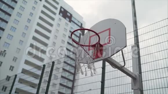 篮球圈在多层建筑的庭院中一个带网的新篮球戒指视频的预览图