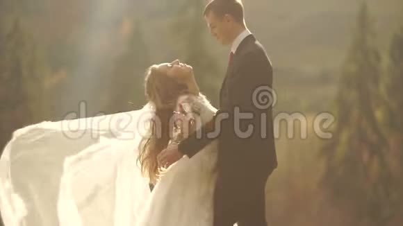 一对新婚夫妇在金色的群山中尽情地享受着彼此温柔地拥抱着这幅画的一半长视频的预览图