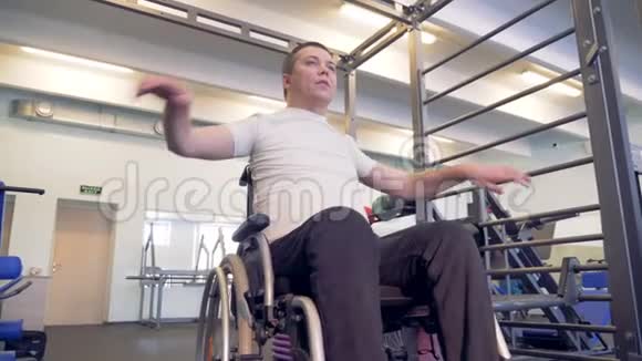 一个在健身房中致残的男性轮椅的健身过程视频的预览图