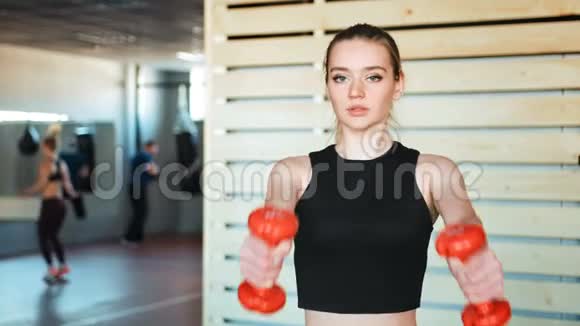 健身女孩在健身房举起哑铃视频的预览图