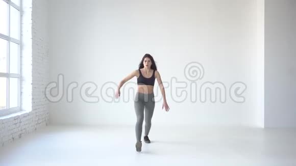 这位瘦瘦的运动女人做着猛冲和举起手的完整视角4k怀特工作室的位置视频的预览图