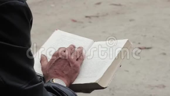 手里拿着一本书的老人在书的框架和手中视频的预览图