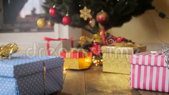 特写4k镜头镜头在圣诞树下的礼物间飞舞视频的预览图
