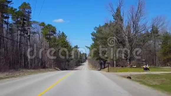 在春日期间驾驶农村森林司机的观点沿着美丽的阳光林地树木视频的预览图