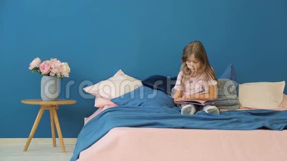 一个小女孩正在床上看书视频的预览图
