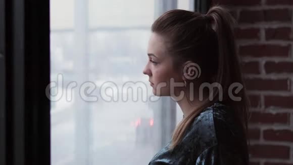 悲伤的女孩望着窗外转过头来视频的预览图