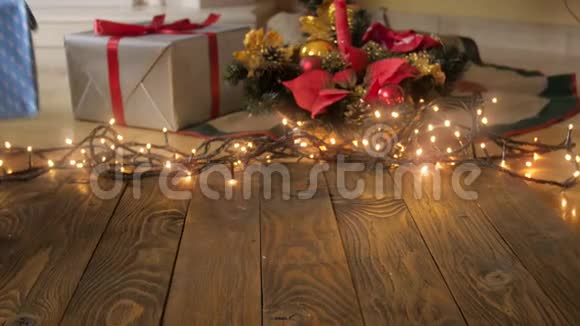 摄像机的4k视频慢慢地移动到木制桌子上走向圣诞树人们把礼物放进盒子里视频的预览图