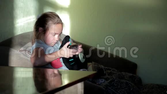 小女孩在家玩电话玩得很热儿童对小工具的依赖视频的预览图
