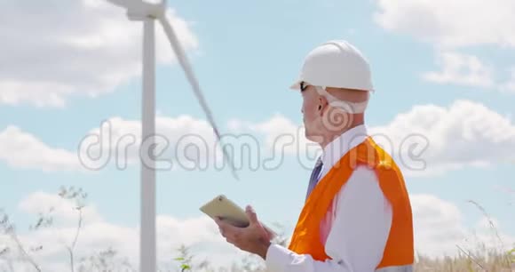 工程师使用平板电脑户外背景风力涡轮机视频的预览图