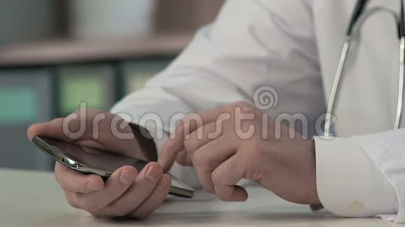 医生的手滑动文件在智能手机上输入文字医疗咨询视频的预览图