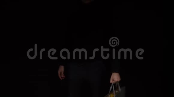 手拿包裹在黑色背景上复制空间购物销售折扣视频的预览图