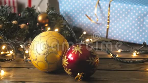 特写镜头彩色狒狒圣诞礼物和发光的光加兰在木制的背景视频的预览图