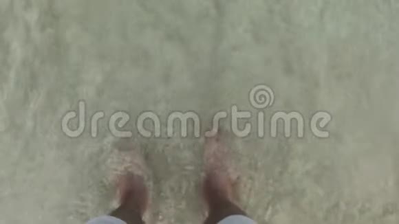 男腿穿短裤站在沙滩上和海浪海水的角度雄足在海涛和湿沙顶景视频的预览图