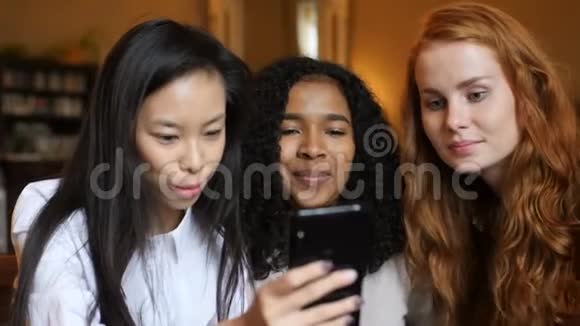 多民族女孩嘲笑电话平板电脑和咖啡馆视频的预览图