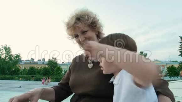 奶奶和孙子在公园夏天读一本书视频的预览图