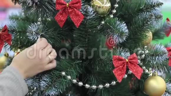 新年雌性手把玩具放在圣诞树上视频的预览图