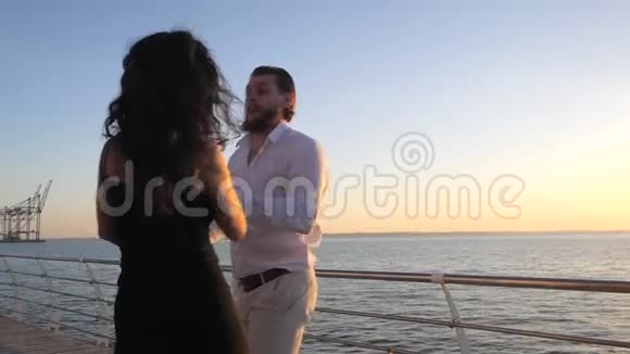 一对年轻迷人的夫妇在海边或海洋附近跳舞的拉丁巴哈塔的肖像日光背景夏日时光浪漫视频的预览图