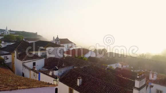 雾蒙蒙的早晨在奥比多斯鸟瞰红色瓷砖屋顶视频的预览图