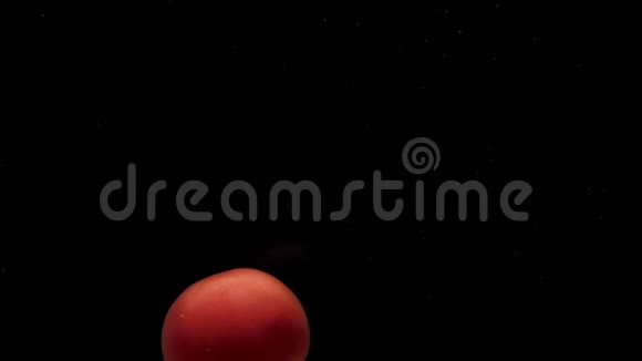 一个红番茄躺在透明的水中黑底视频的预览图