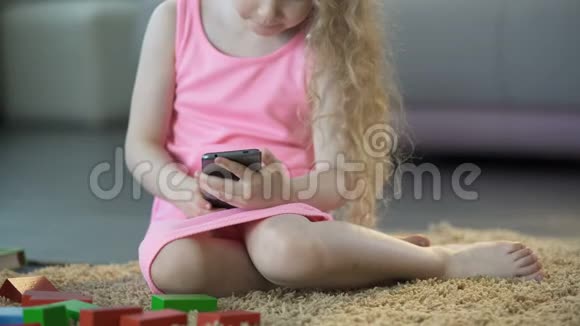 忙碌的小女孩使用手机小工具在智能手机上玩游戏科技视频的预览图