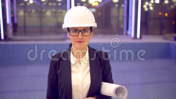 女工程师或建筑师的肖像戴着头盔看相机的女建筑师的肖像视频的预览图