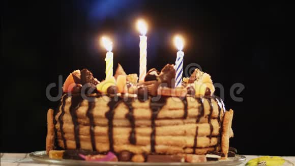 带三支蜡烛的黑暗房间里的蛋糕生日派对视频的预览图