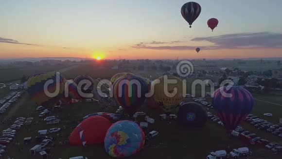在热空气气球节上吹奏热气球的鸟瞰图视频的预览图