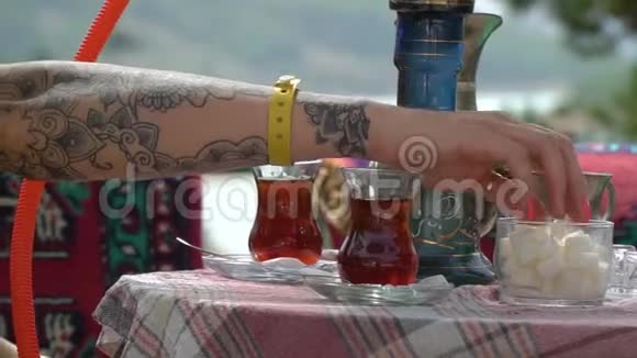 女人手把糖放进茶里搅拌它视频的预览图