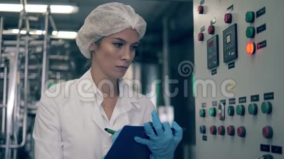 女工厂工人在一家乳品厂检查一台机器视频的预览图