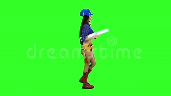 戴着建筑工具的戴头盔的女孩在绿色的背景下着身子视频的预览图