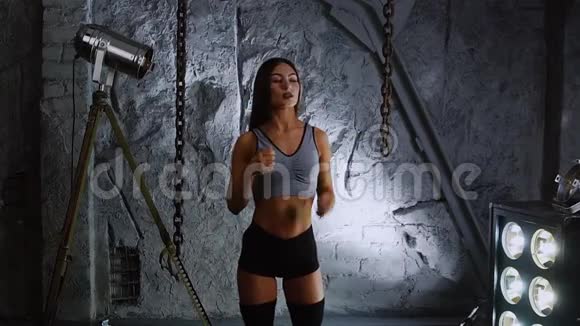 在石墙的背景下身材苗条的女运动员在训练前给你的脖子做热身运动视频的预览图