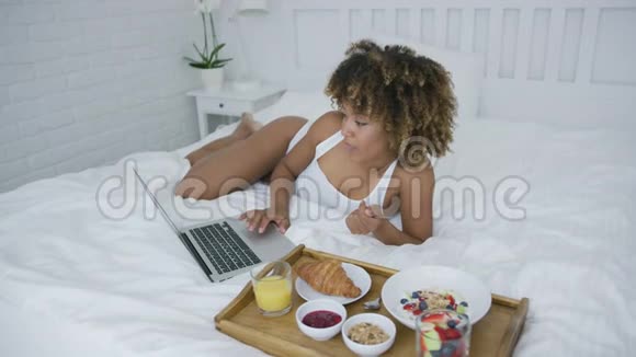 吃饭时使用笔记本电脑的内容女性视频的预览图
