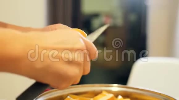 在家庭厨房里剥土豆一个女人拿着刀剥土豆在碗里打扫烹饪食物视频的预览图