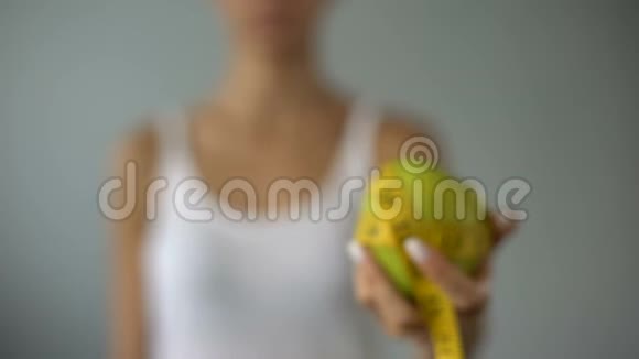 女孩拿着苹果绑着测量带健康饮食的概念素食主义者视频的预览图