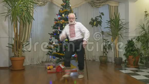 有趣的老人在圣诞树附近跳舞视频的预览图
