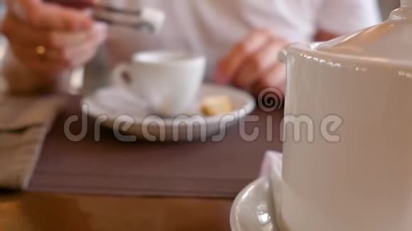 年轻人手里拿着一杯茶喝着桌上的一杯茶近距离射击视频的预览图