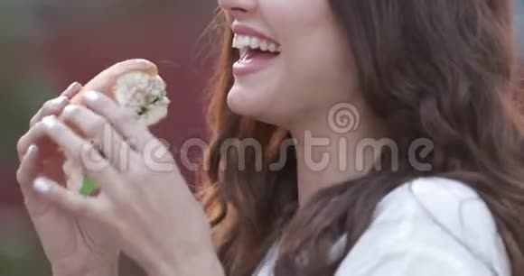 年轻女孩戴着时尚的太阳镜嘴唇明亮享受美味的汉堡视频的预览图