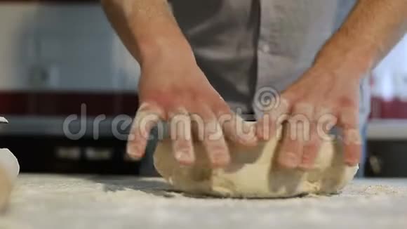 男人手在厨房的桌子上准备披萨面团视频的预览图
