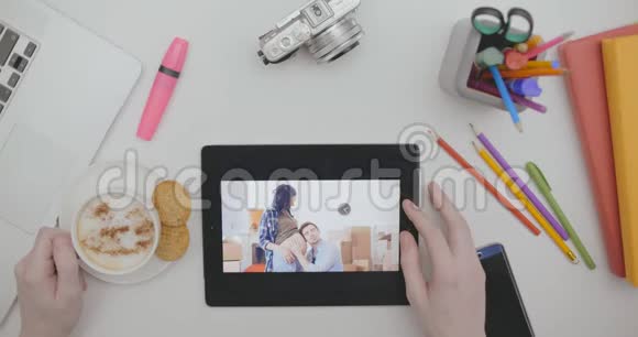 桌面上平板电脑屏幕上的家庭照片视频的预览图