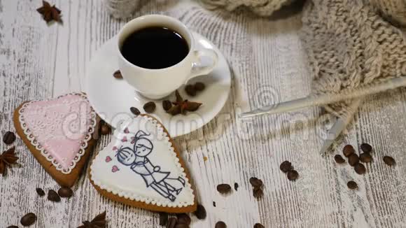 爱情观念情人节一杯新鲜煮好的咖啡和木制背景的心形姜饼视频的预览图