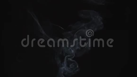 薄薄的灰烟缓缓升起优雅地在黑色的背景上缠绕起来黑色和白色的烟雾从视频的预览图