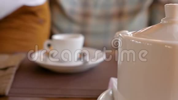 年轻人手里拿着一杯茶喝着桌上的一杯茶近距离射击视频的预览图