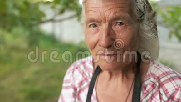 她花园里一个非常老的女人的可爱的大肖像一个女人的头上戴着一个头巾仔细地看了看深不可测视频的预览图