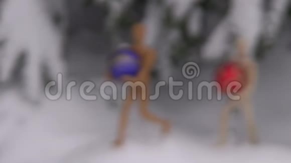 两个木制艺术家假人在冷杉附近的雪地里放圣诞彩球视频的预览图