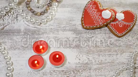 恋爱关系情人节两个心形姜饼和燃烧蜡烛在木制背景女性视频的预览图