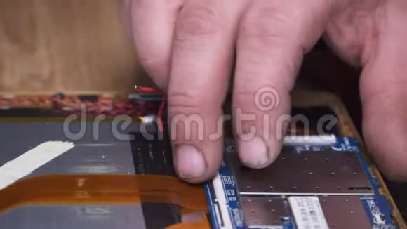 一名电子技术人员为一台破碎的平板电脑进行了维修视频的预览图