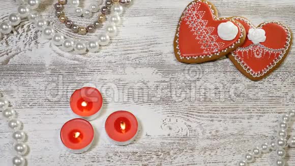 恋爱关系情人节两个心形姜饼和燃烧蜡烛在木制背景女性视频的预览图