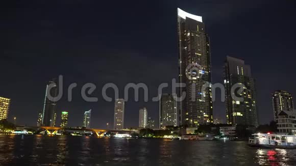 河岸上有办公室的公司大楼大城市的夜晚商务窗口的灯光视频的预览图